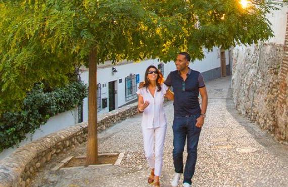 Two travelers walking down a cobblestone path in Greece.